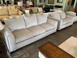 A living room filled with white couches and chairs.