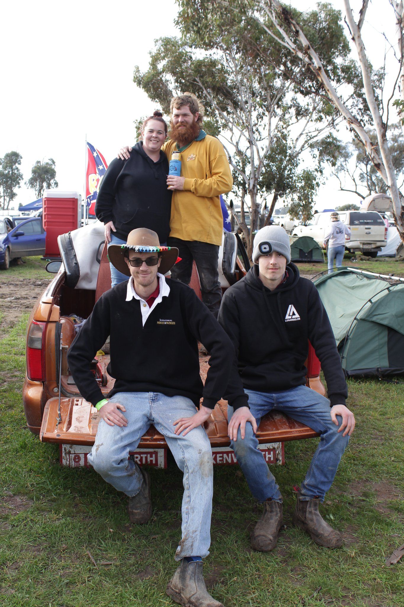 A group of people sitting on the back of a truck with a sign that says ' sydney ' on it