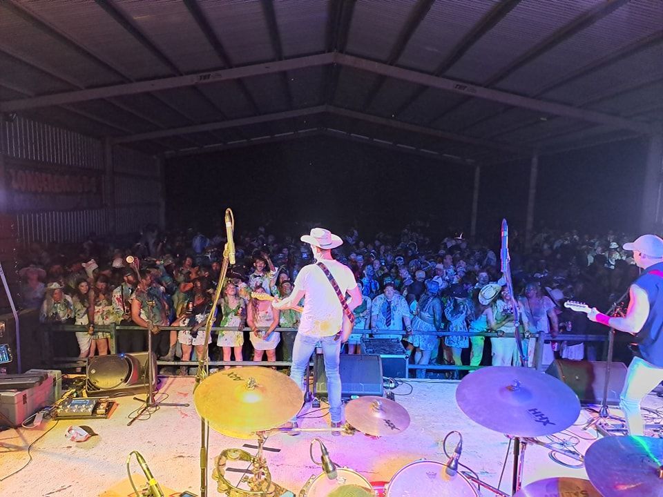 A man playing a guitar on stage in front of a crowd