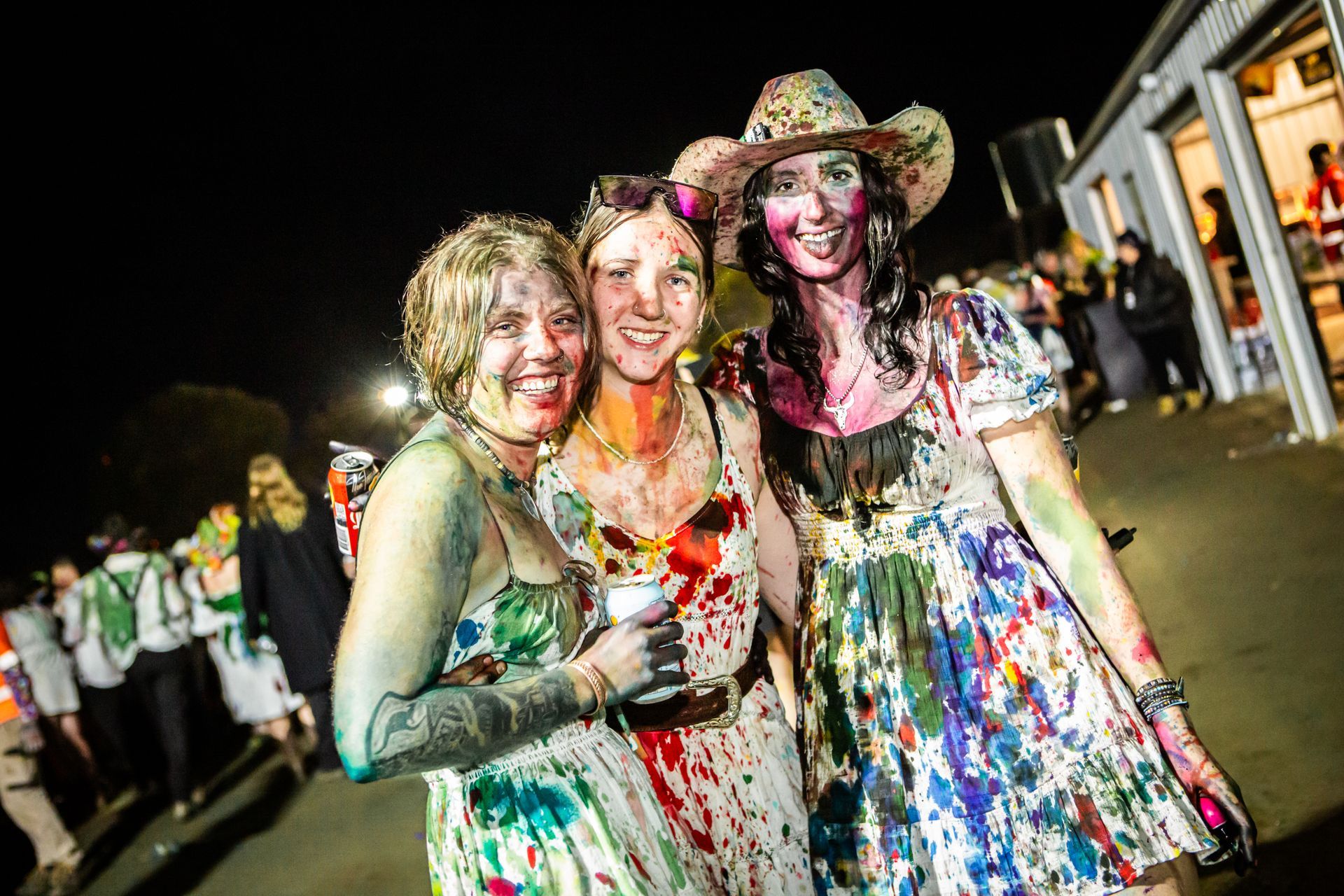 Three women covered in paint are posing for a picture