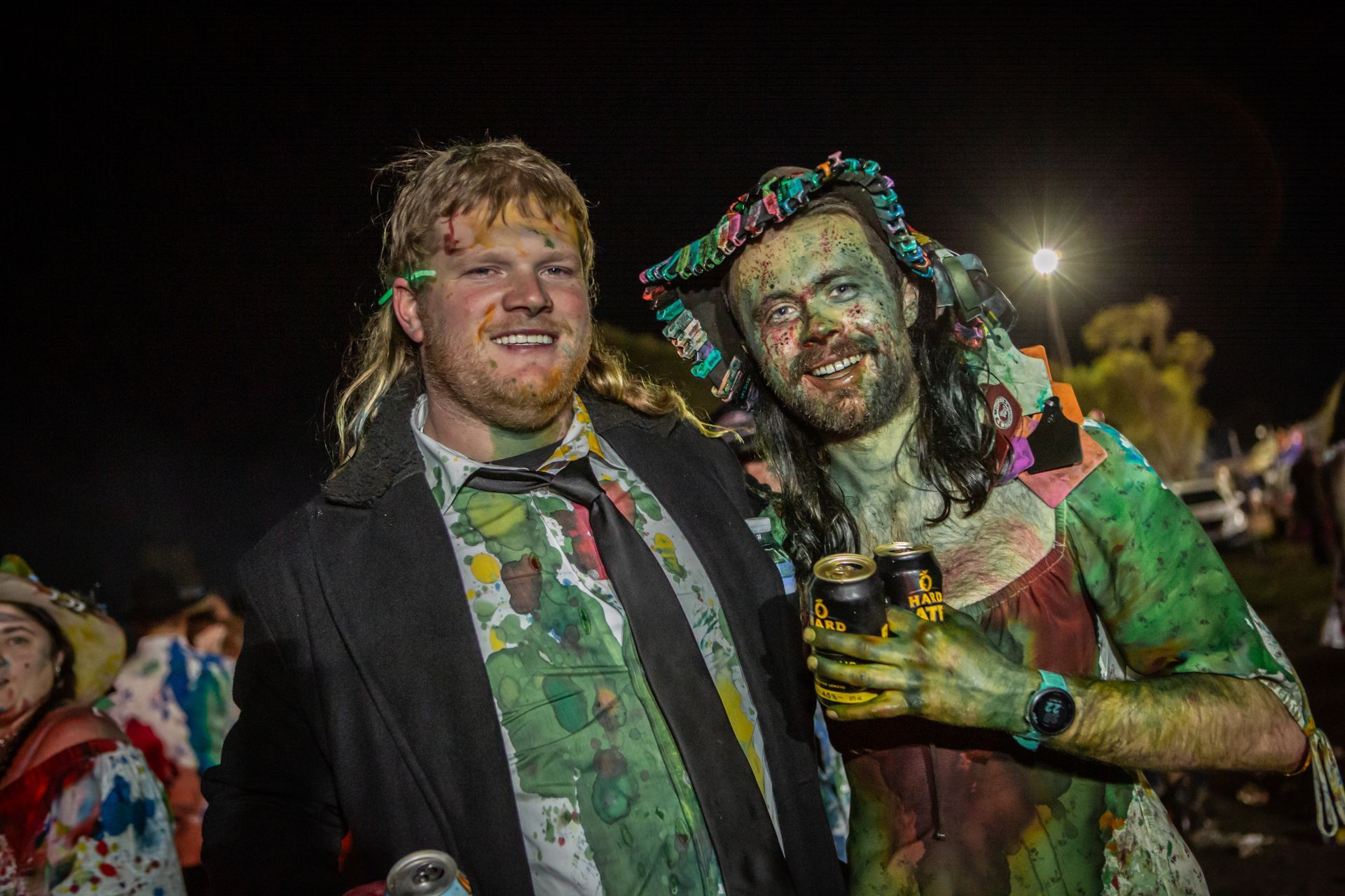 A man and a woman covered in paint are posing for a picture