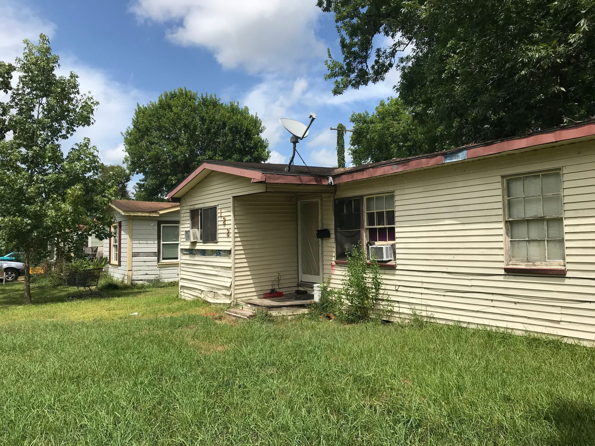 A small white house with a satellite dish on the roof