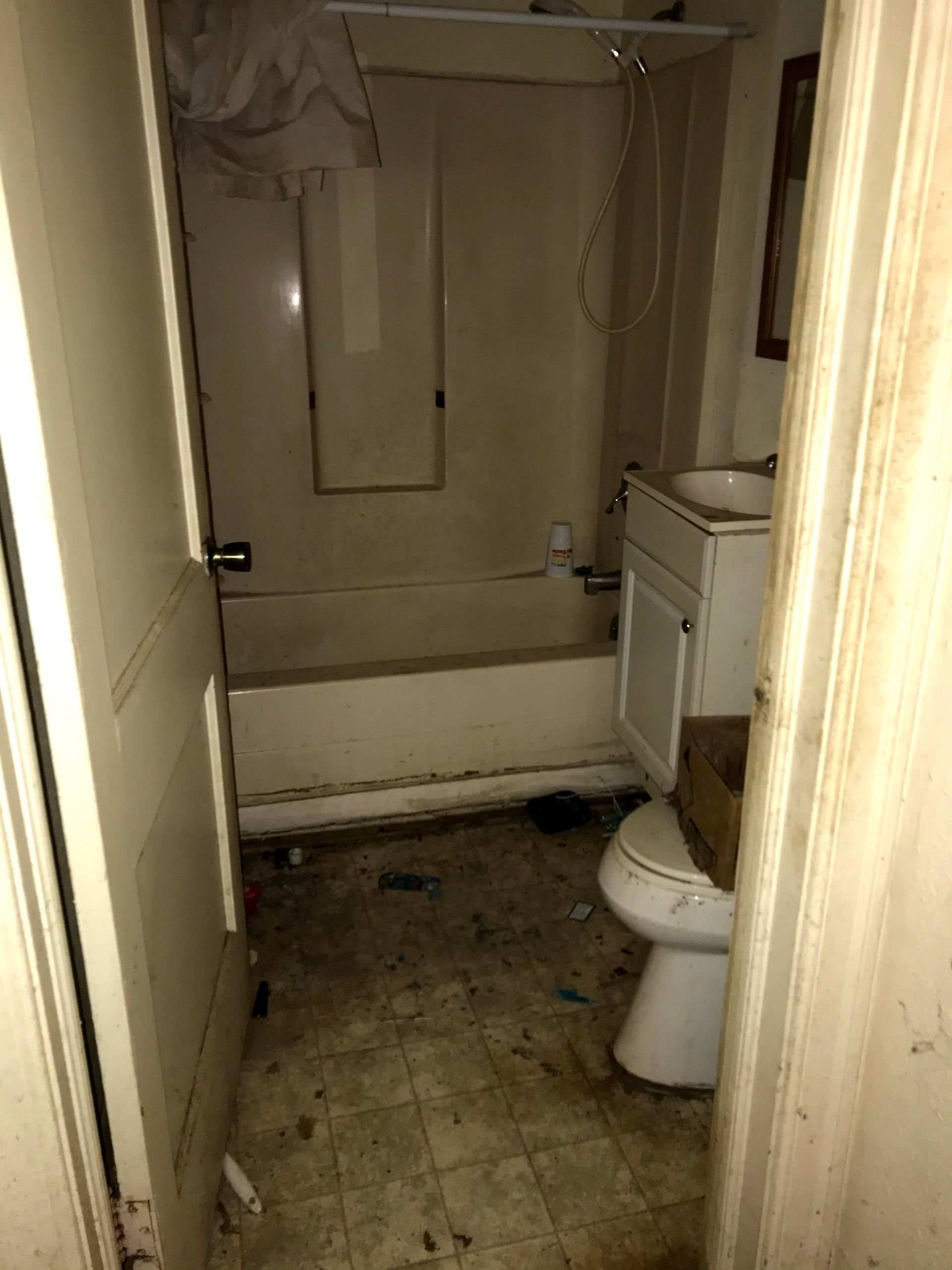 A bathroom with a tub , toilet , sink and mirror.