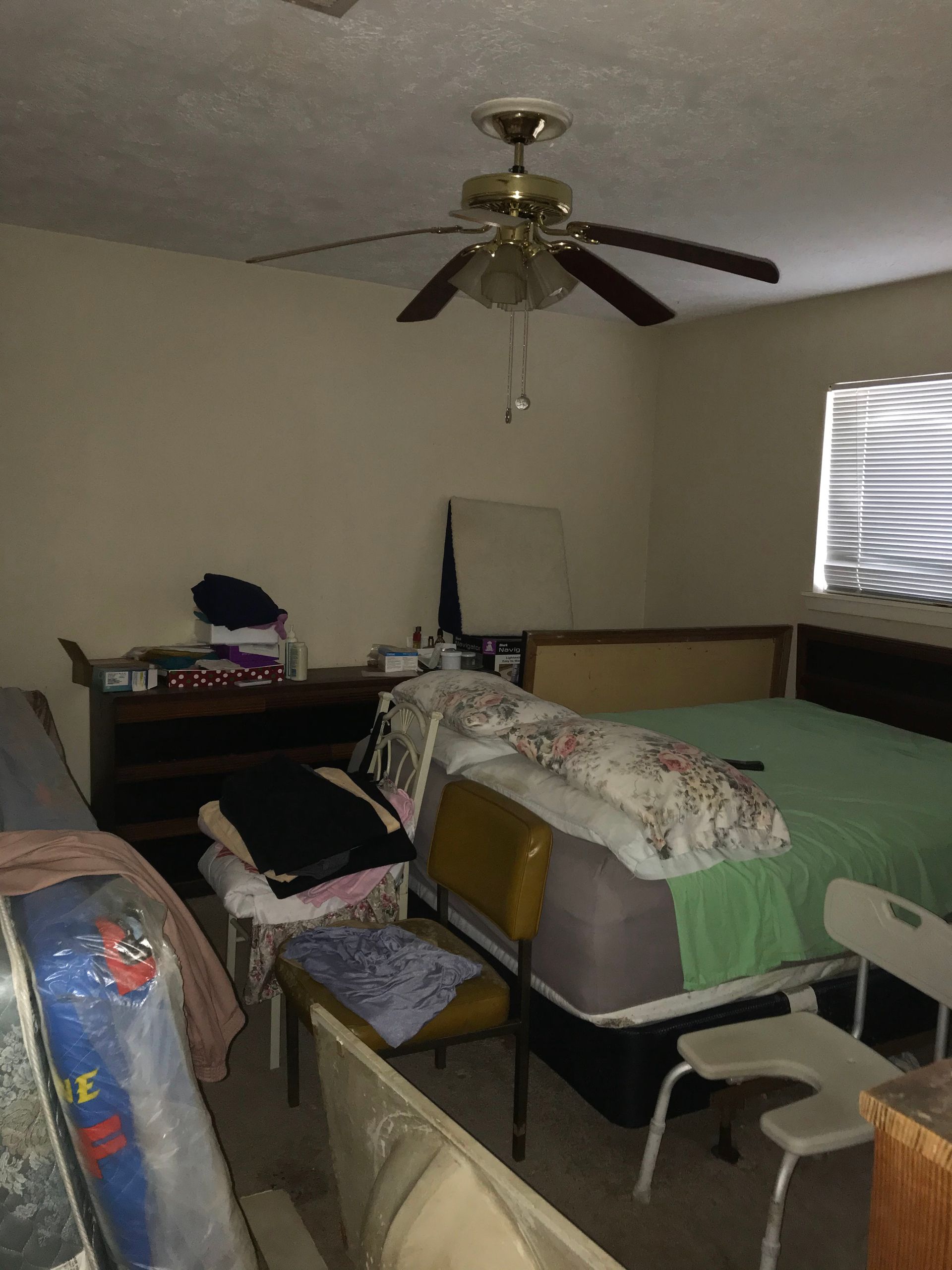 A bedroom with two beds and a ceiling fan