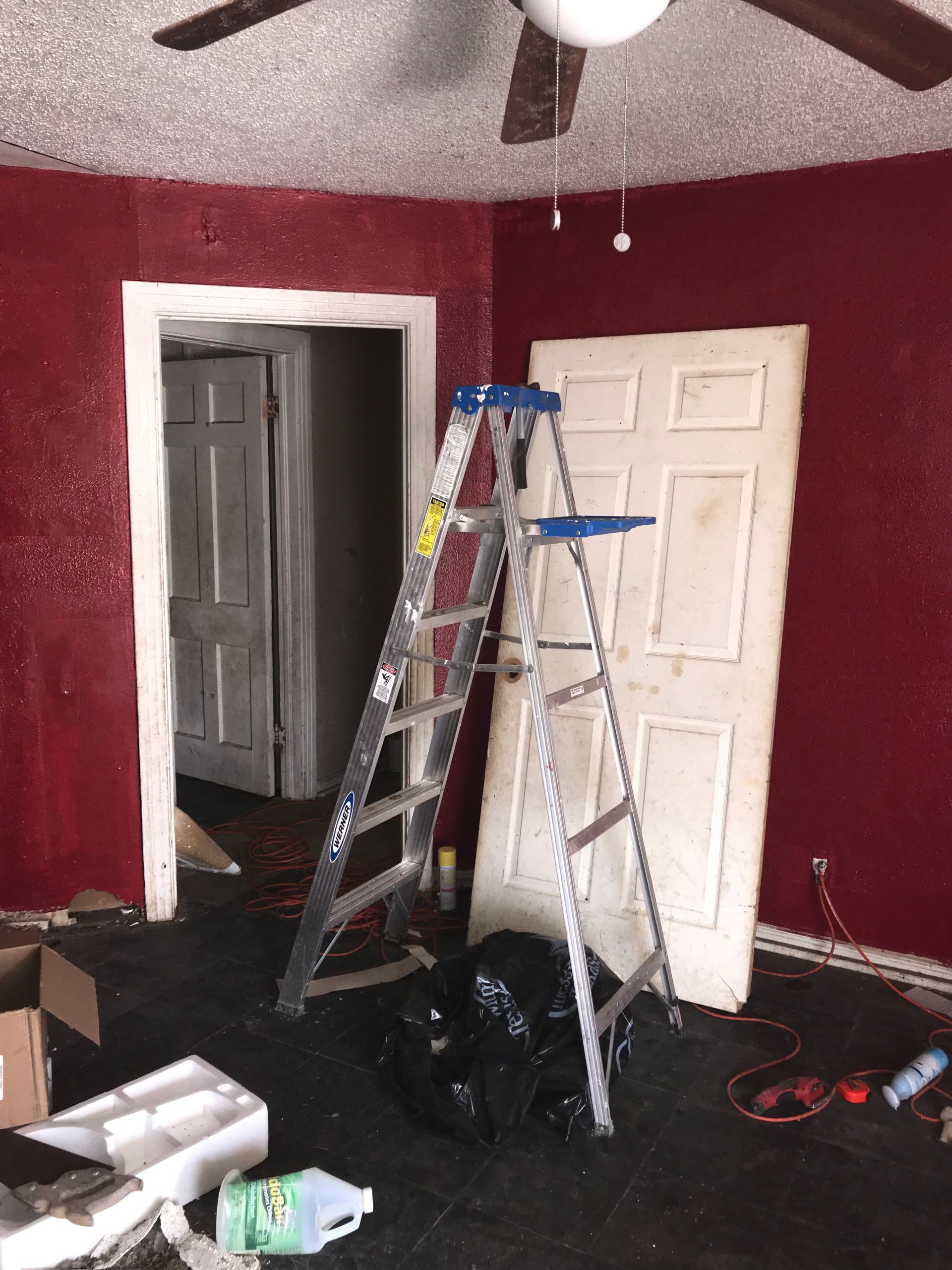 A room with red walls and a ladder in the corner