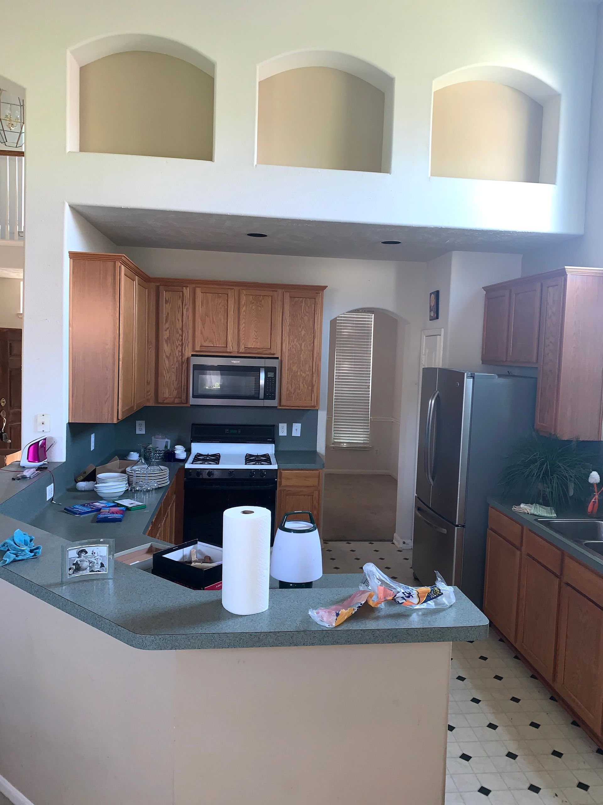 A kitchen with wooden cabinets and a stainless steel refrigerator