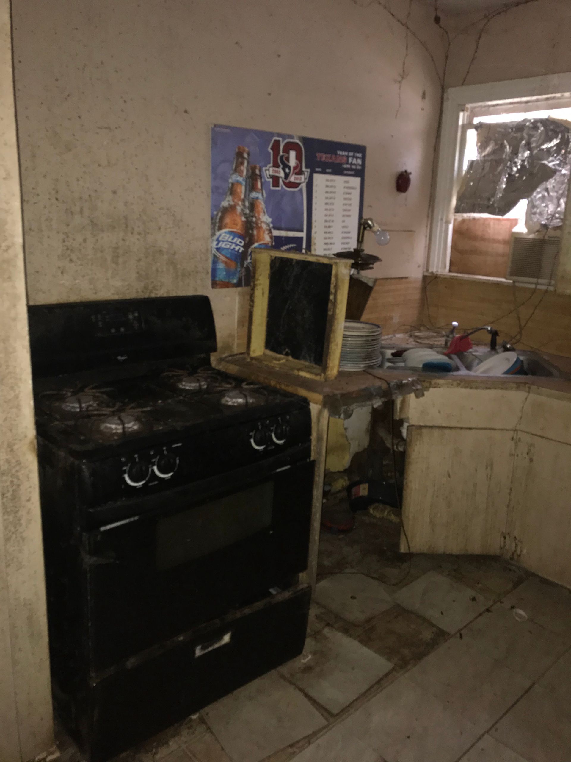 A kitchen with a stove and a pepsi poster on the wall