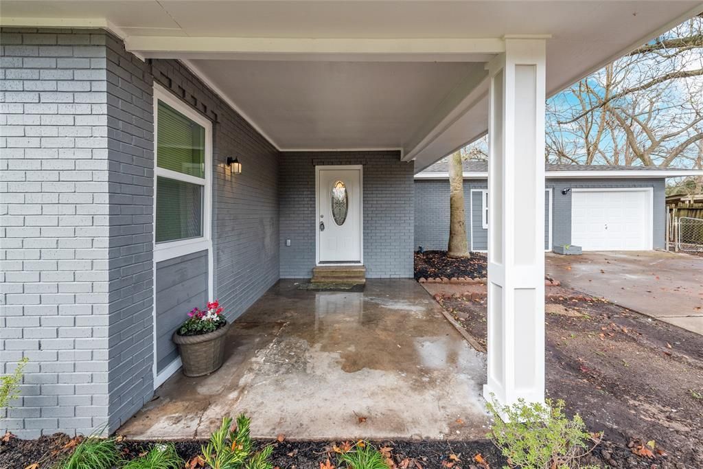 A brick house with a porch and a white door