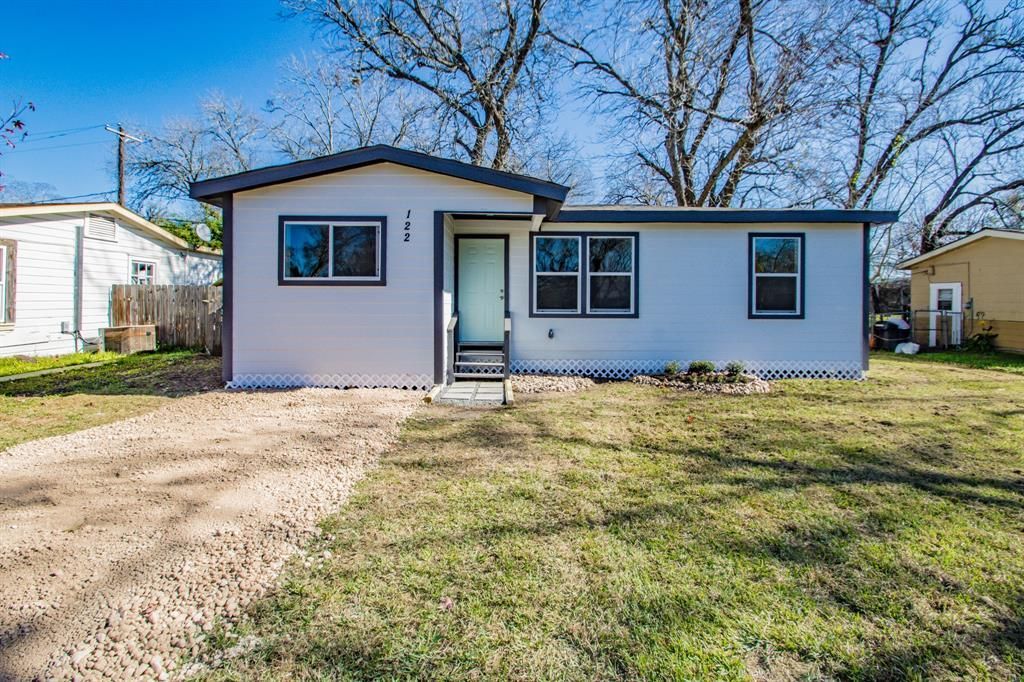 A small white house with a lot of windows is for sale.
