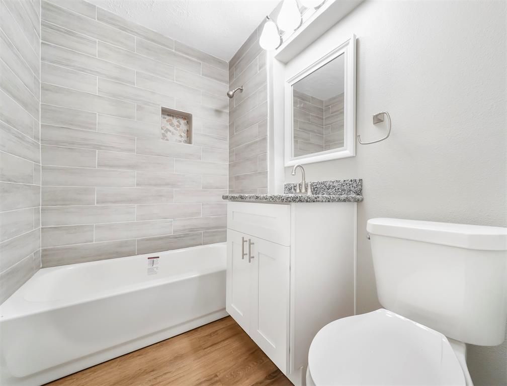 A bathroom with a toilet , sink , and bathtub.