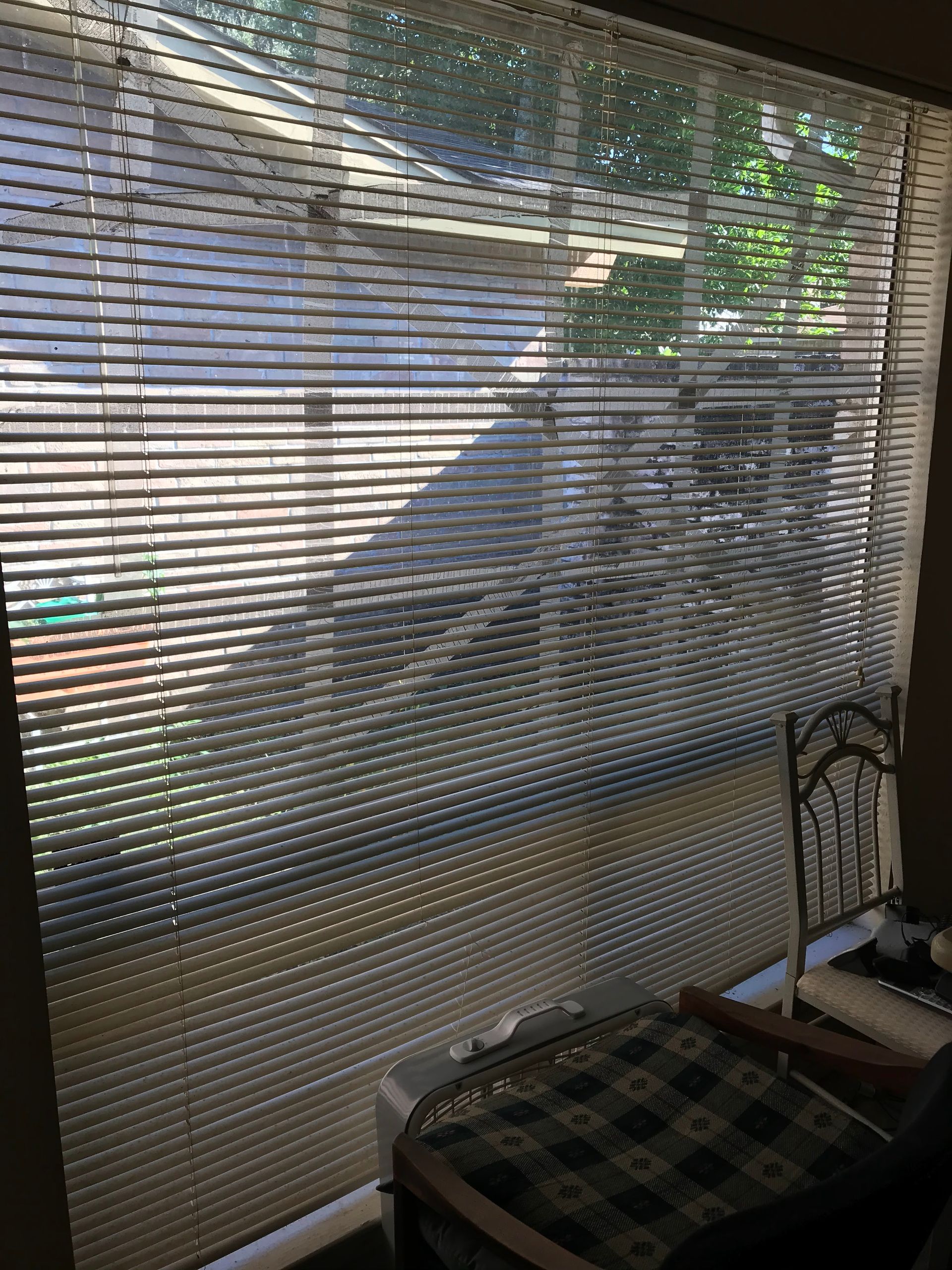 A window with blinds and a chair in front of it