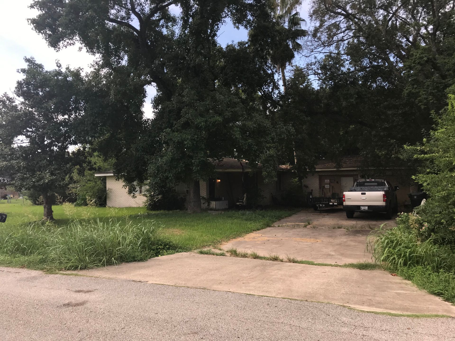 A white truck is parked in a driveway in front of a house.