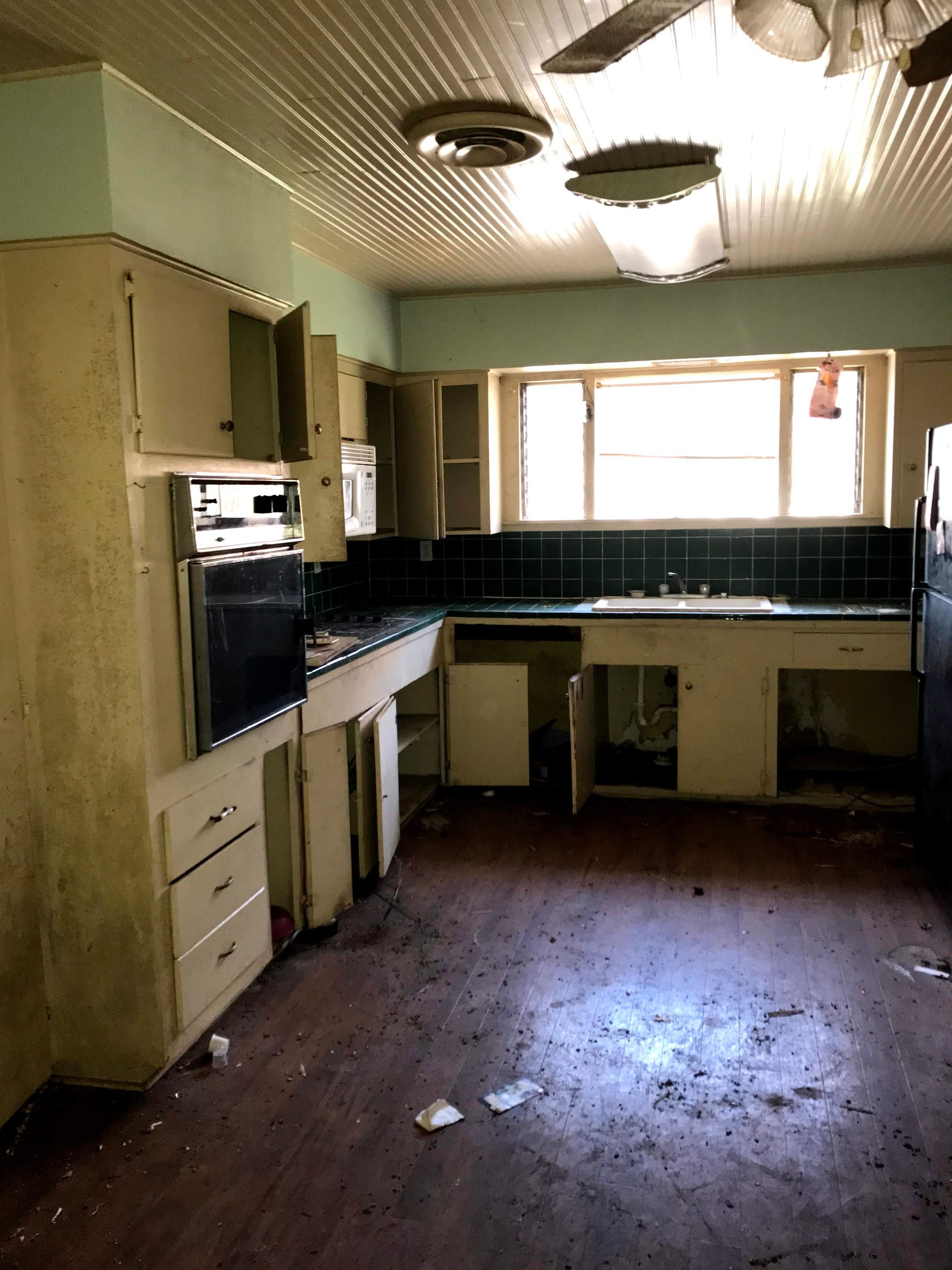 An empty kitchen with a ceiling fan and a sink.
