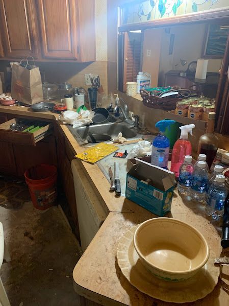 A messy kitchen with a bowl on a table.