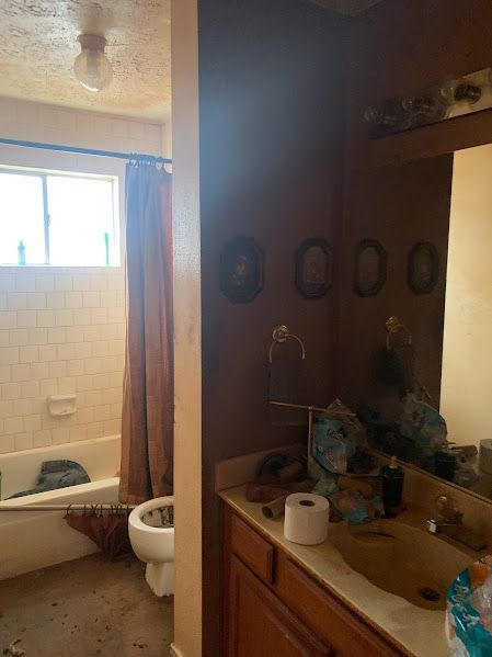 A bathroom with a sink , toilet , bathtub and mirror.