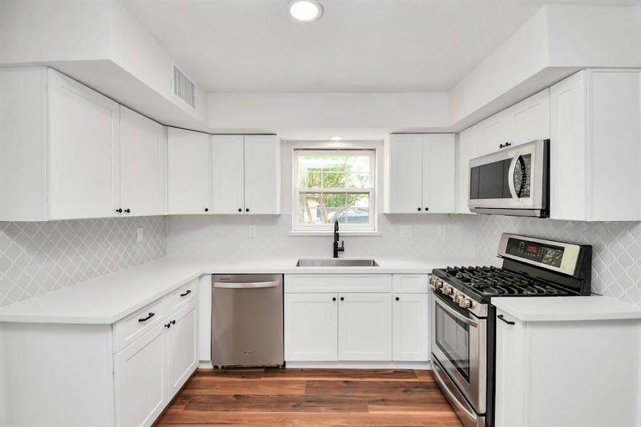 A kitchen with white cabinets and stainless steel appliances.