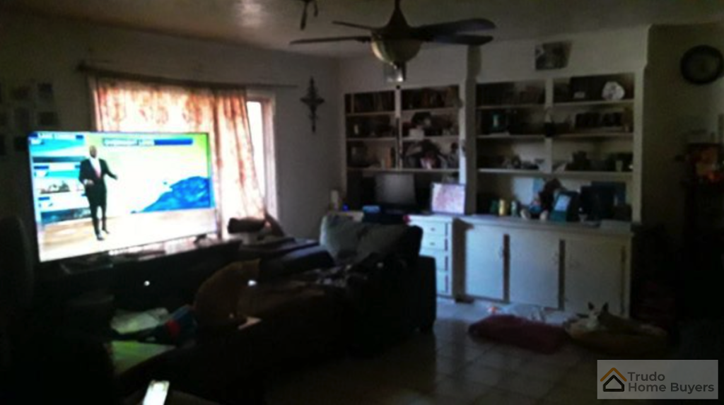 A living room with a tv and a sign that says trade here again
