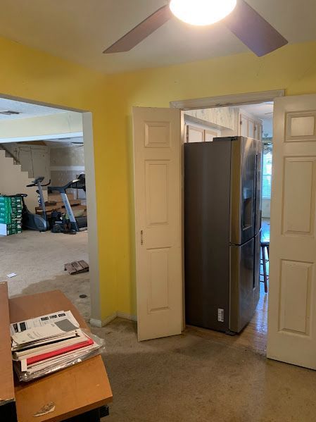 A room with yellow walls and a ceiling fan