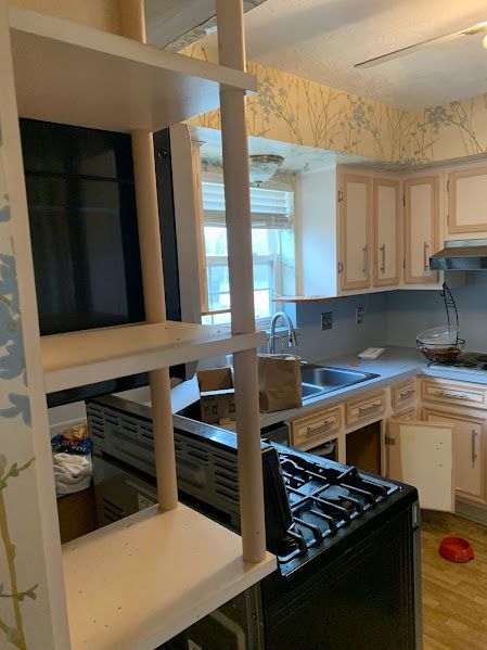 A kitchen with a stove , sink , and microwave.