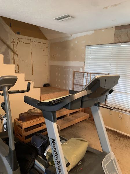 An empty room with a treadmill and an exercise bike