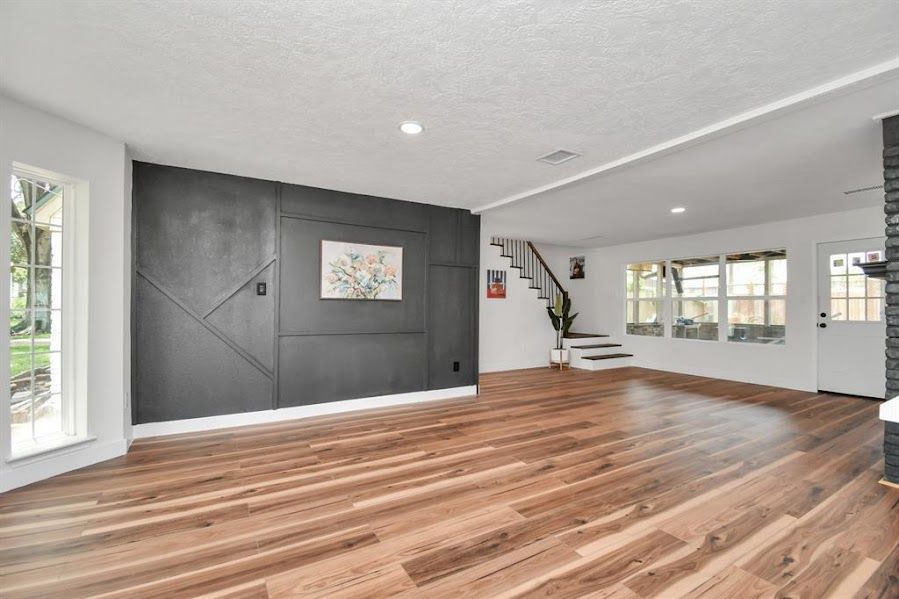 A living room with hardwood floors and a staircase.