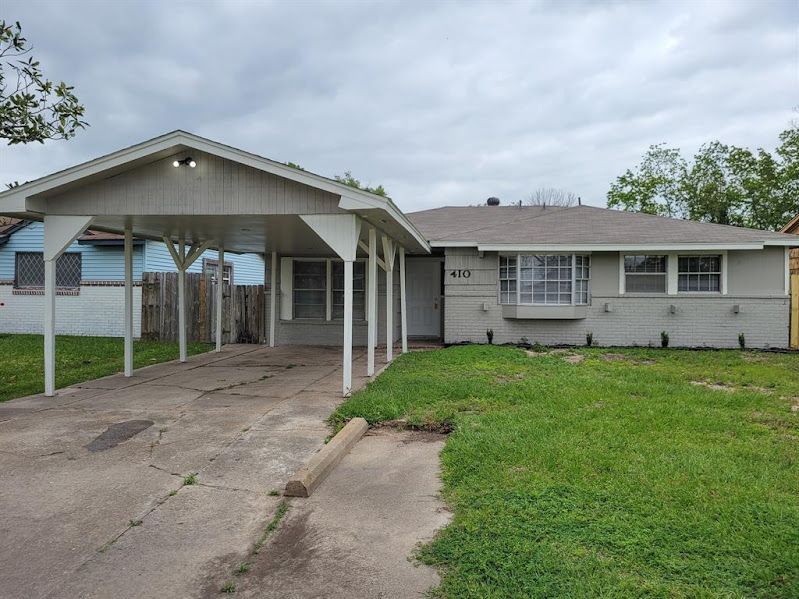 A house with a carport in front of it.