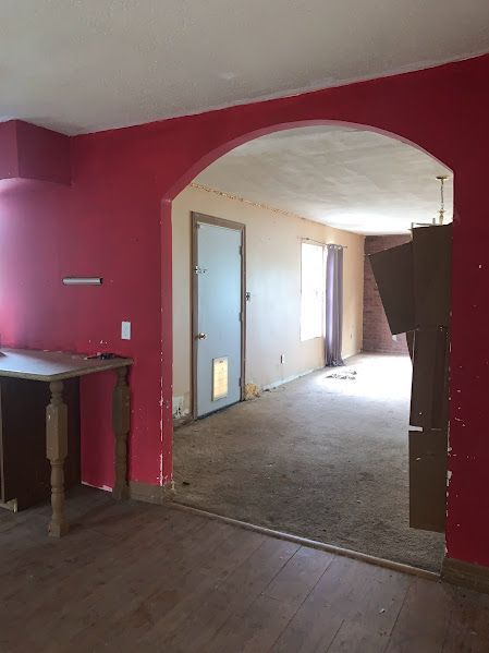 An empty room with red walls and a wooden table