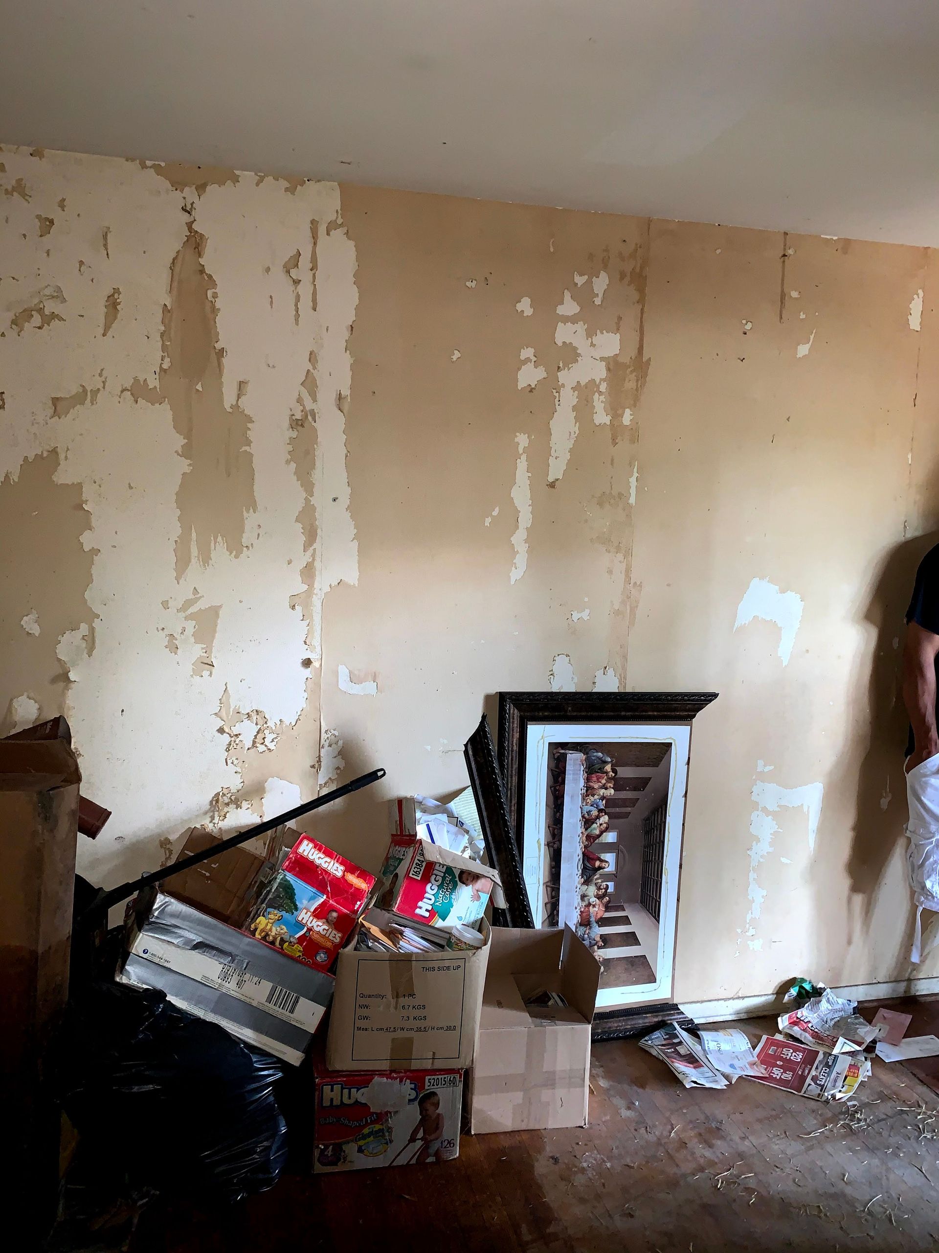 A person is standing in a room with boxes on the floor.