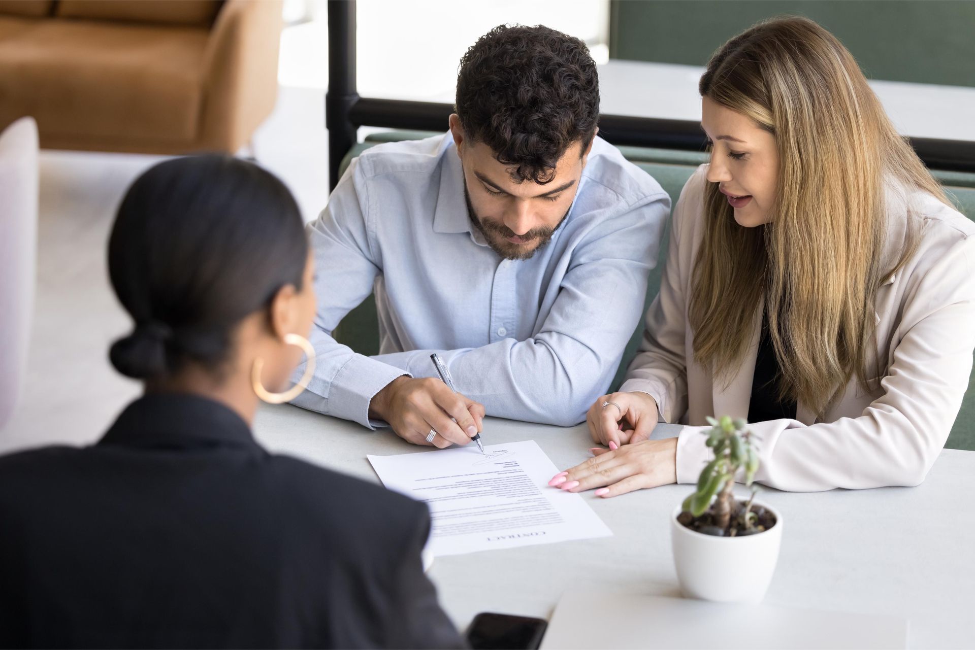 Couple reviewing document with a consultant at a table.