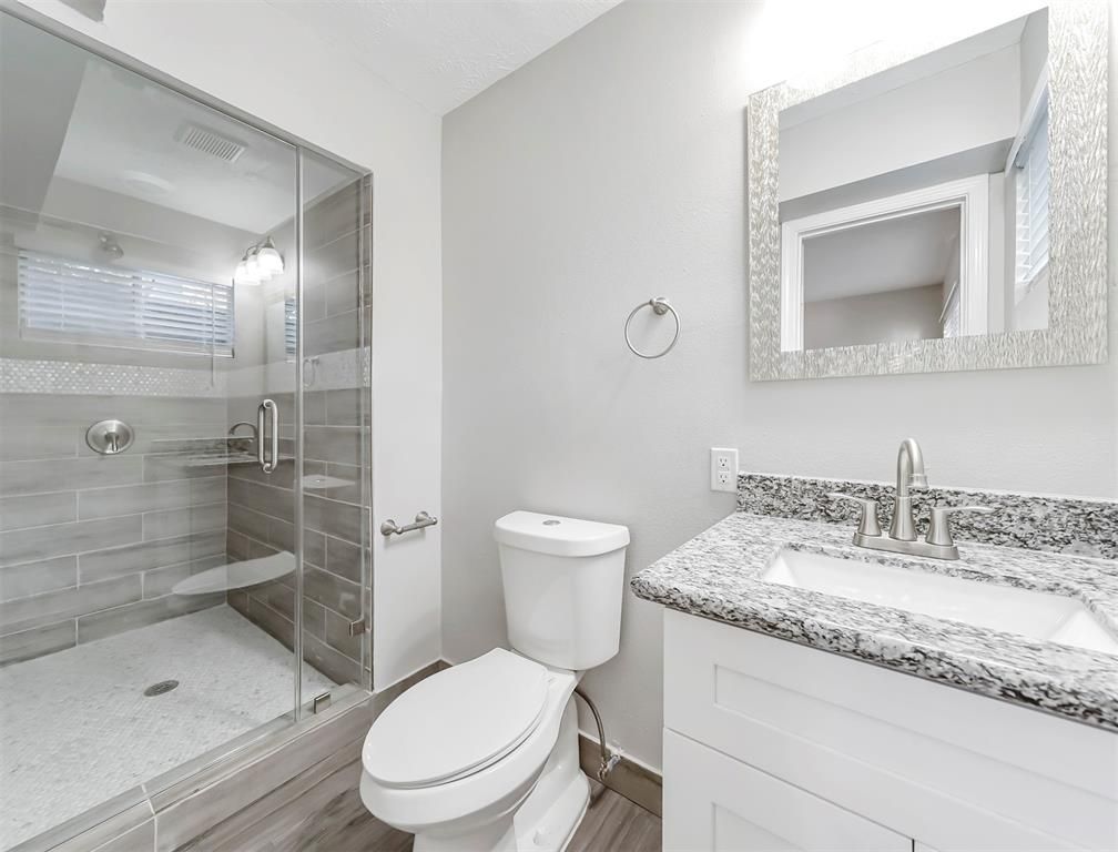 A bathroom with a toilet , sink , and shower.