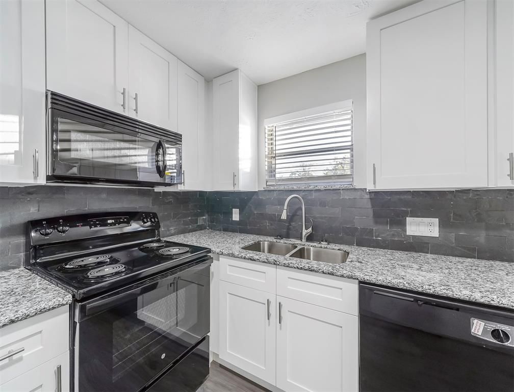 A kitchen with a stove , sink , microwave and dishwasher.