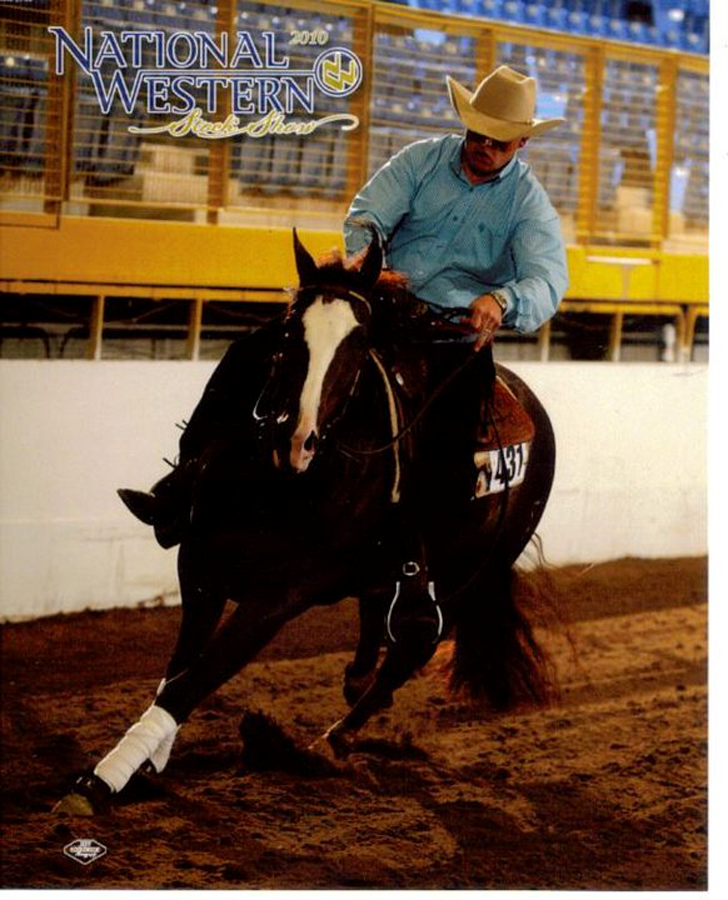 Cowboy riding a dark horse hard around a dirt arena at a rodeo, with National Western branding in the corner
