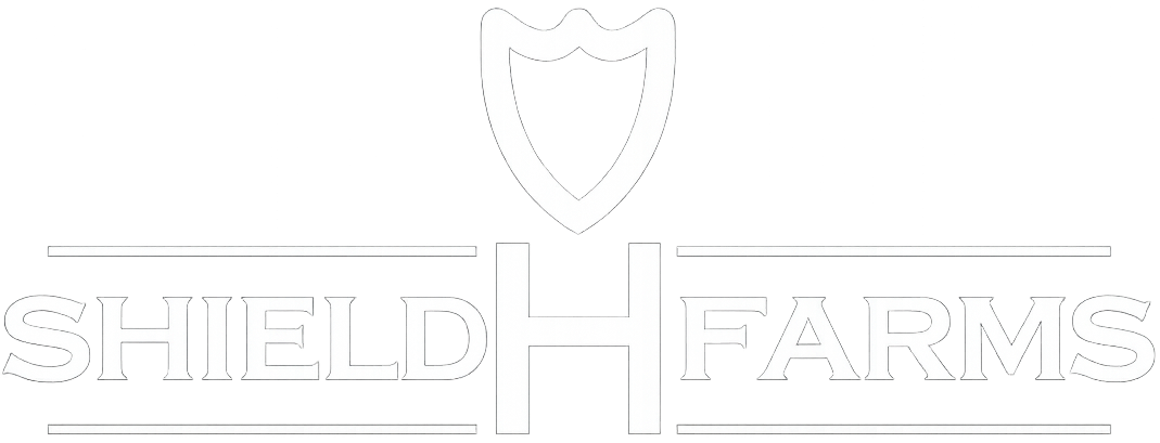 White Shield Farms logo with a shield and text on a light background