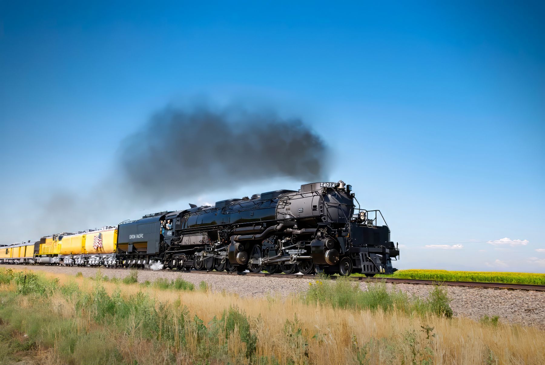 A train is going down the tracks with smoke coming out of it.