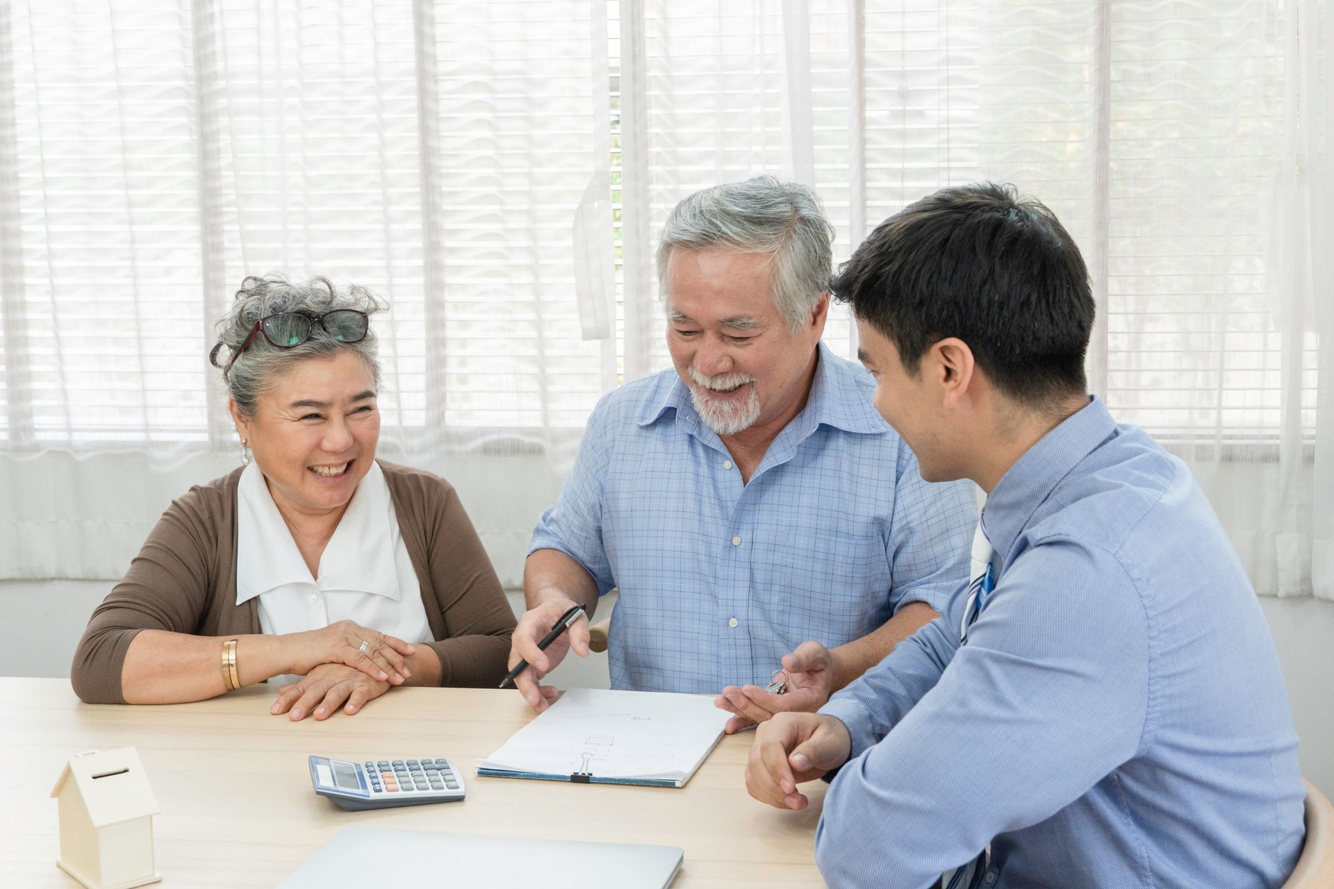 Two older adults sit on a couch reviewing papers in a cozy living room. Two older adults sit on a couch reviewing papers in a cozy living room.