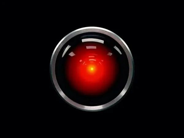 Glowing red robot eye with metallic silver ring on a black background
