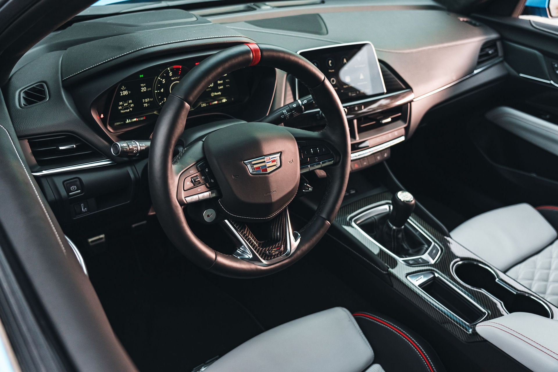 Luxury car interior with black dashboard, red accents, and center console, viewed from the driver’s seat