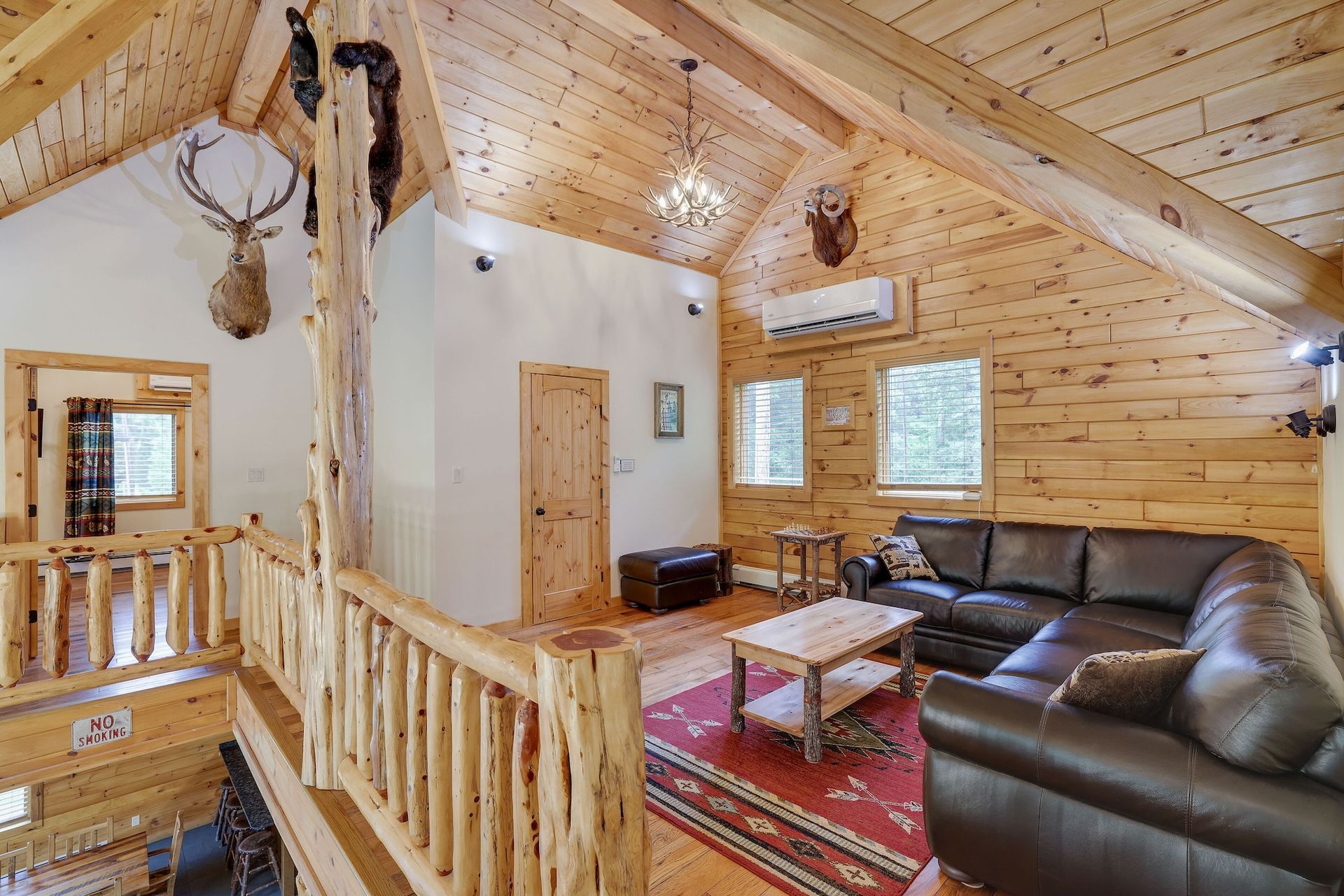 A living room in a log cabin with a couch and a table.
