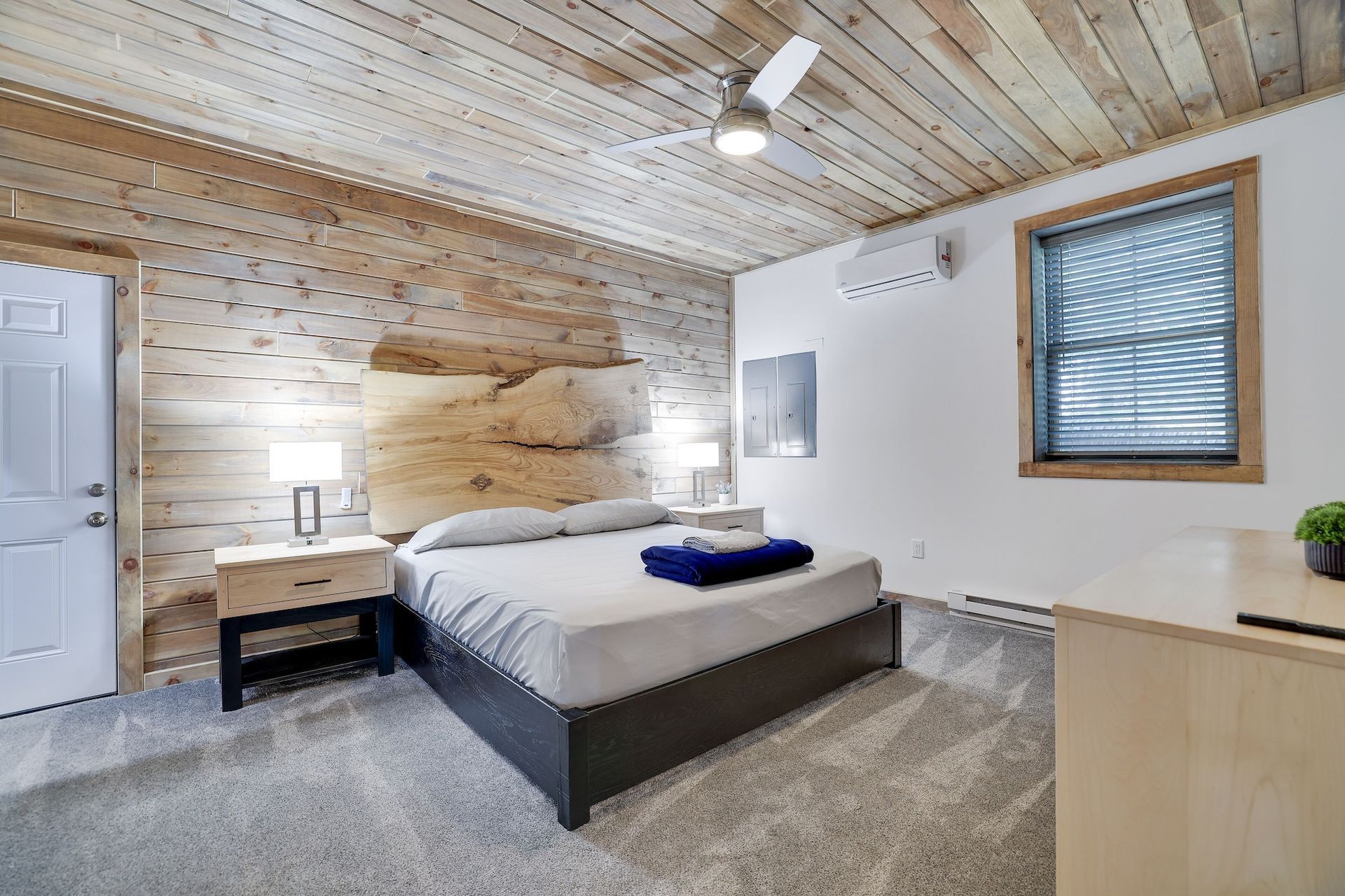 A bedroom with a king size bed and a ceiling fan.