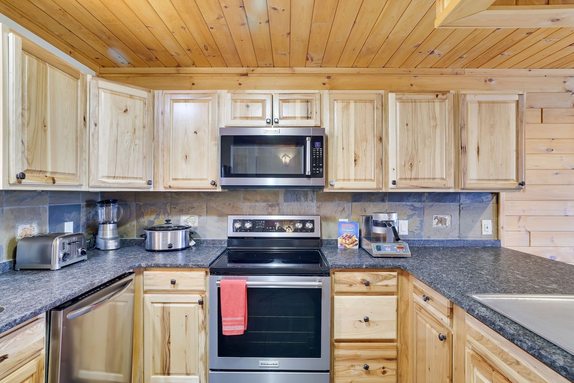 A kitchen with stainless steel appliances and wooden cabinets