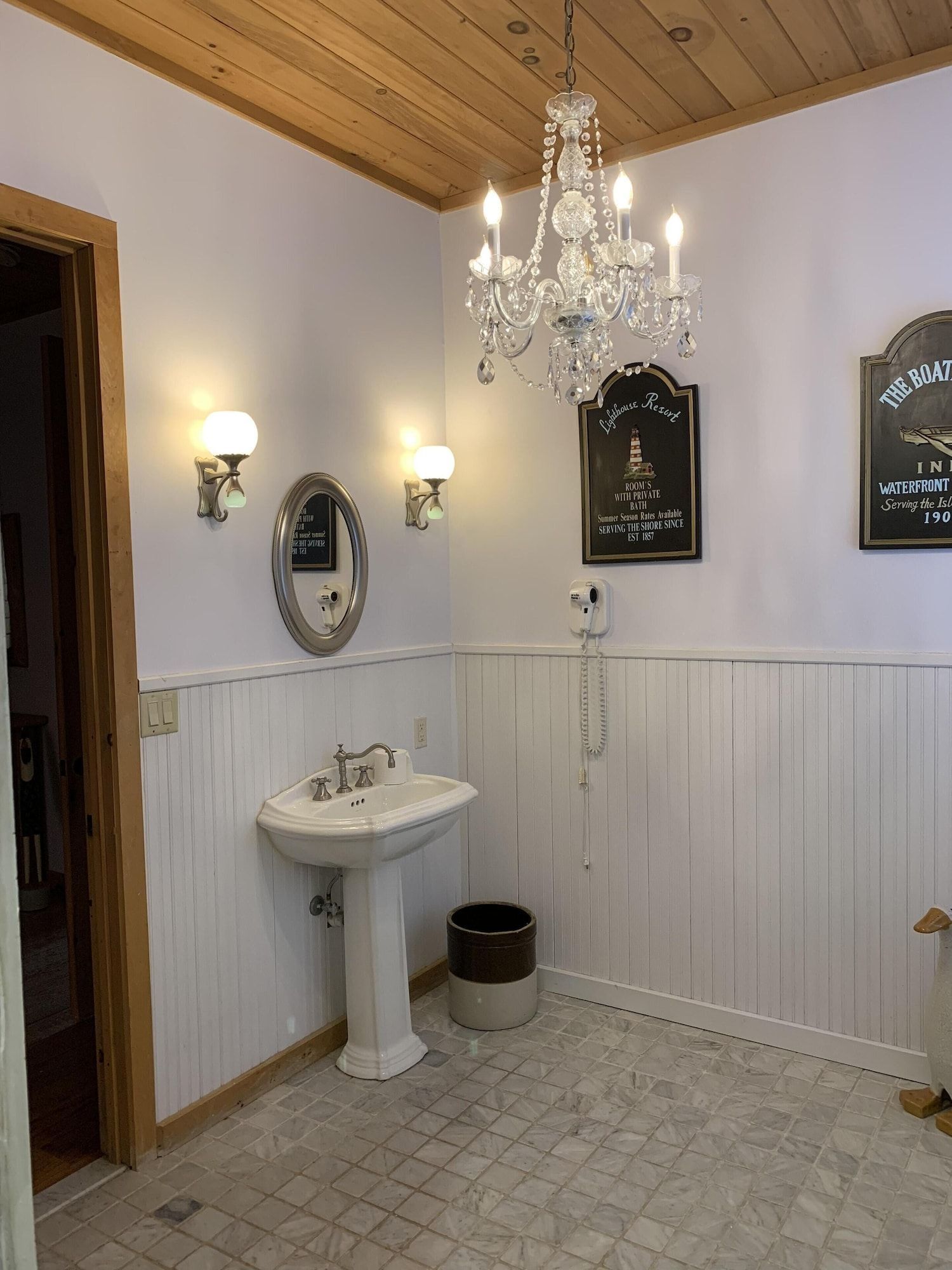 A bathroom with a sink , mirror and chandelier.
