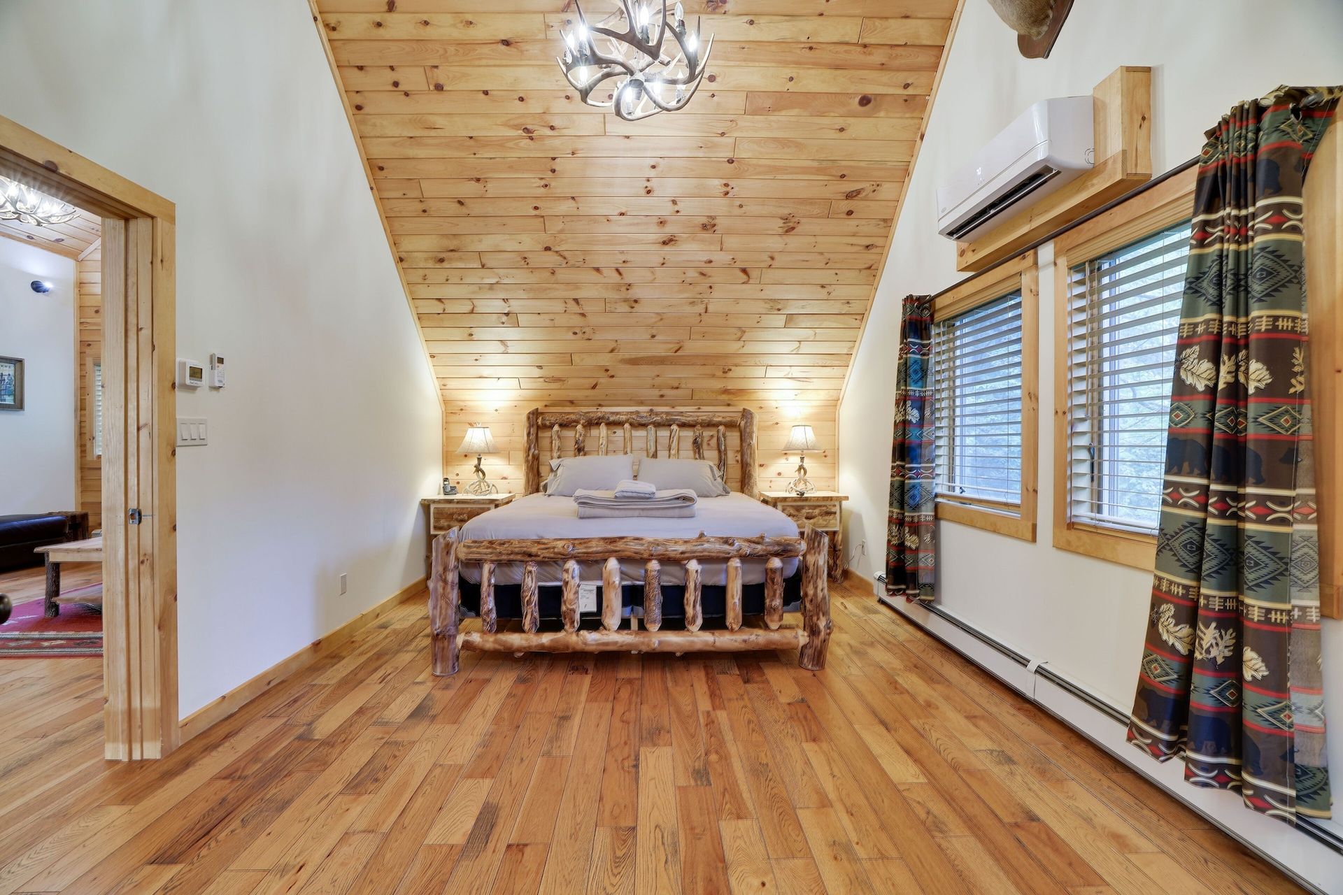 A bedroom with a wooden bed and hardwood floors.