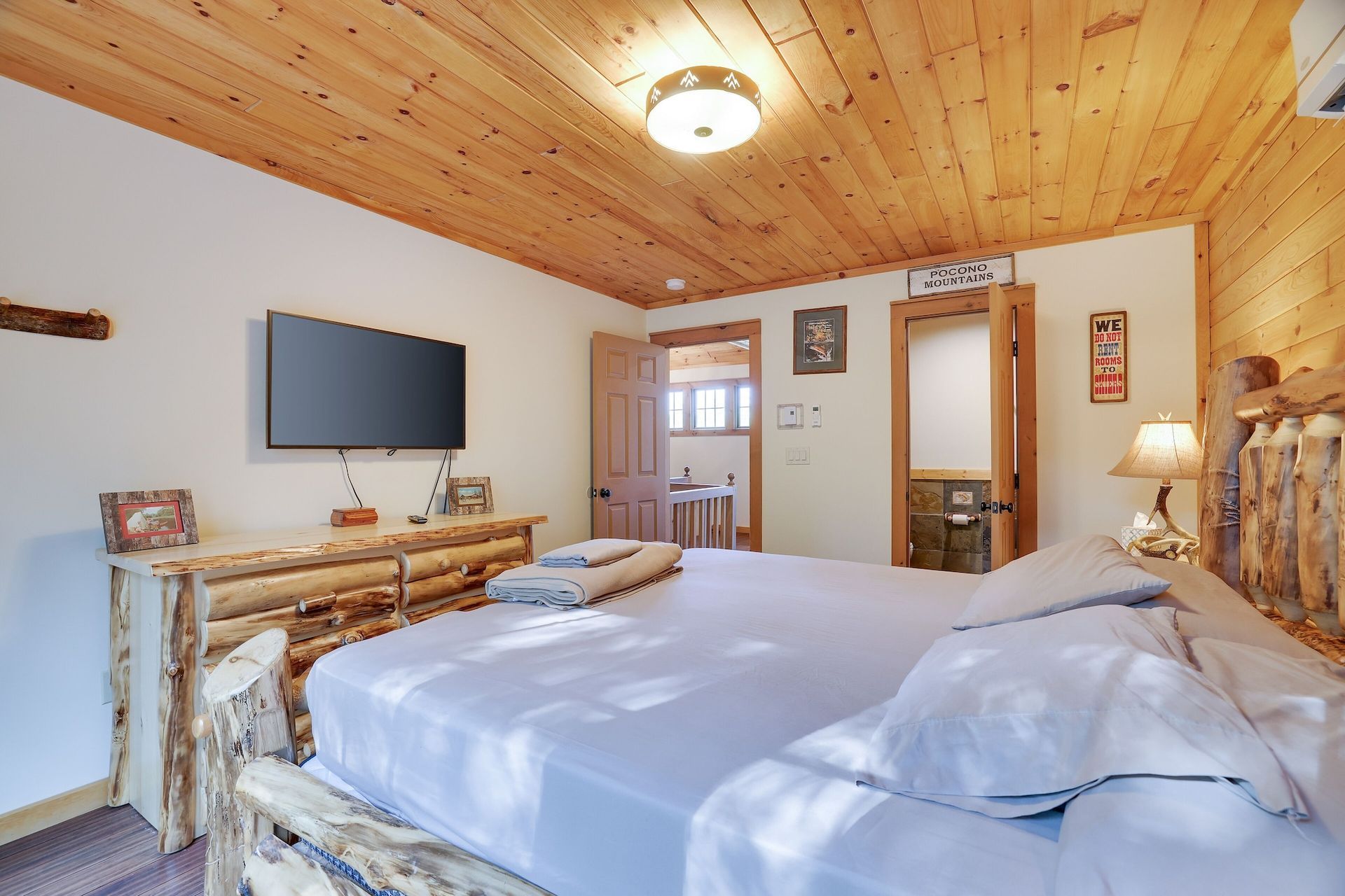 A bedroom with a king size bed and a flat screen tv.