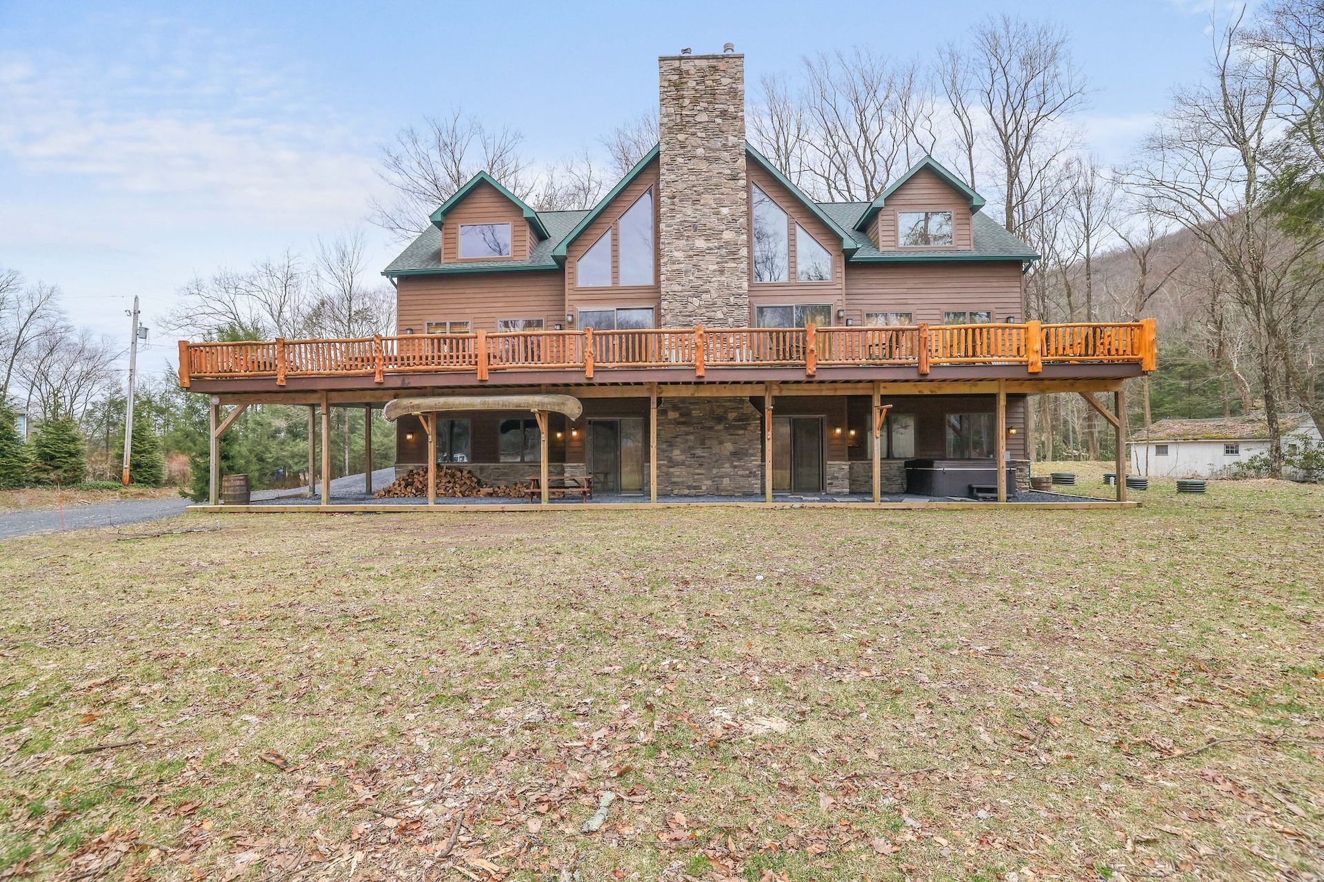 A large house with a large deck in the middle of a field.