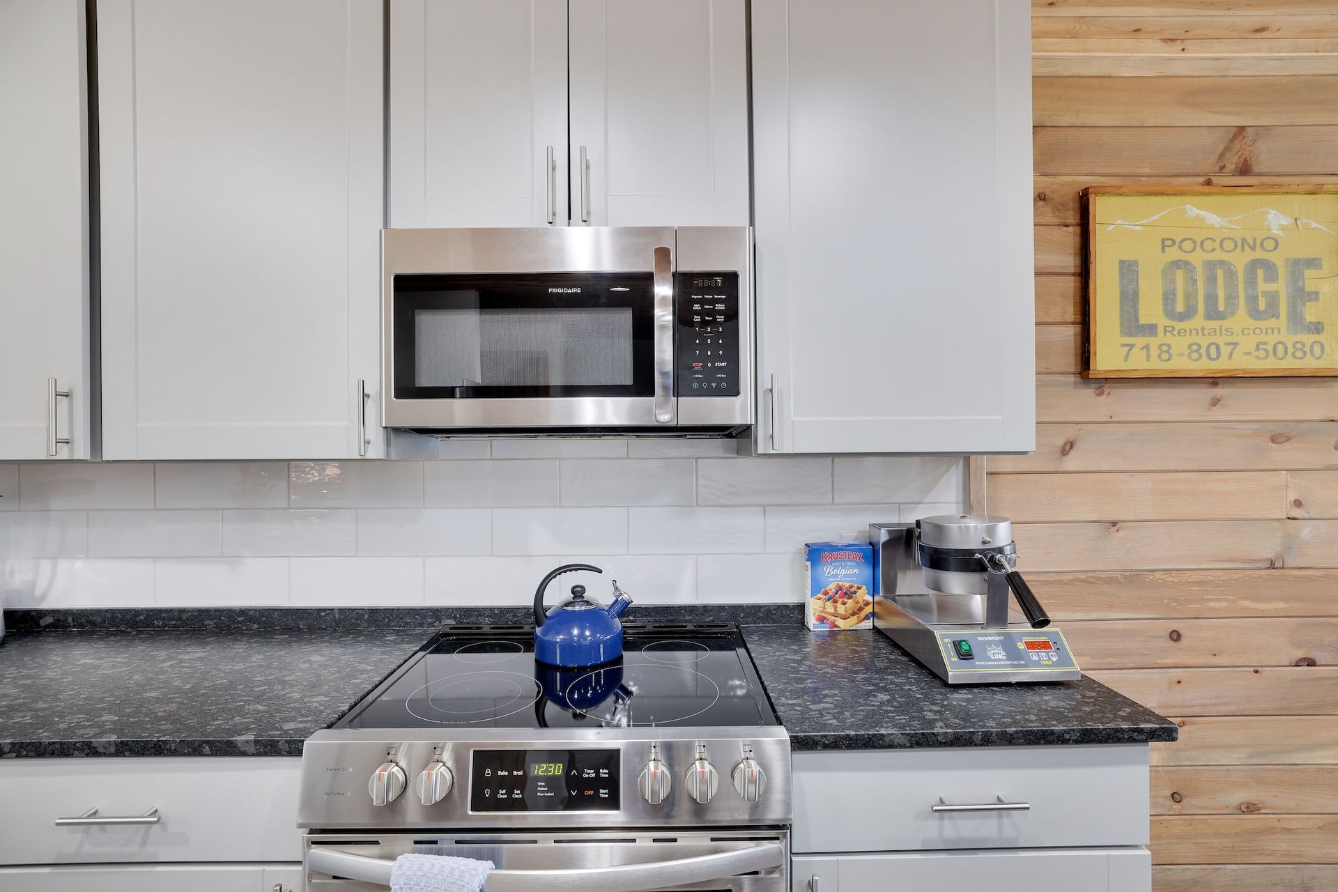 A kitchen with a stove , microwave , and a sign that says lodge.