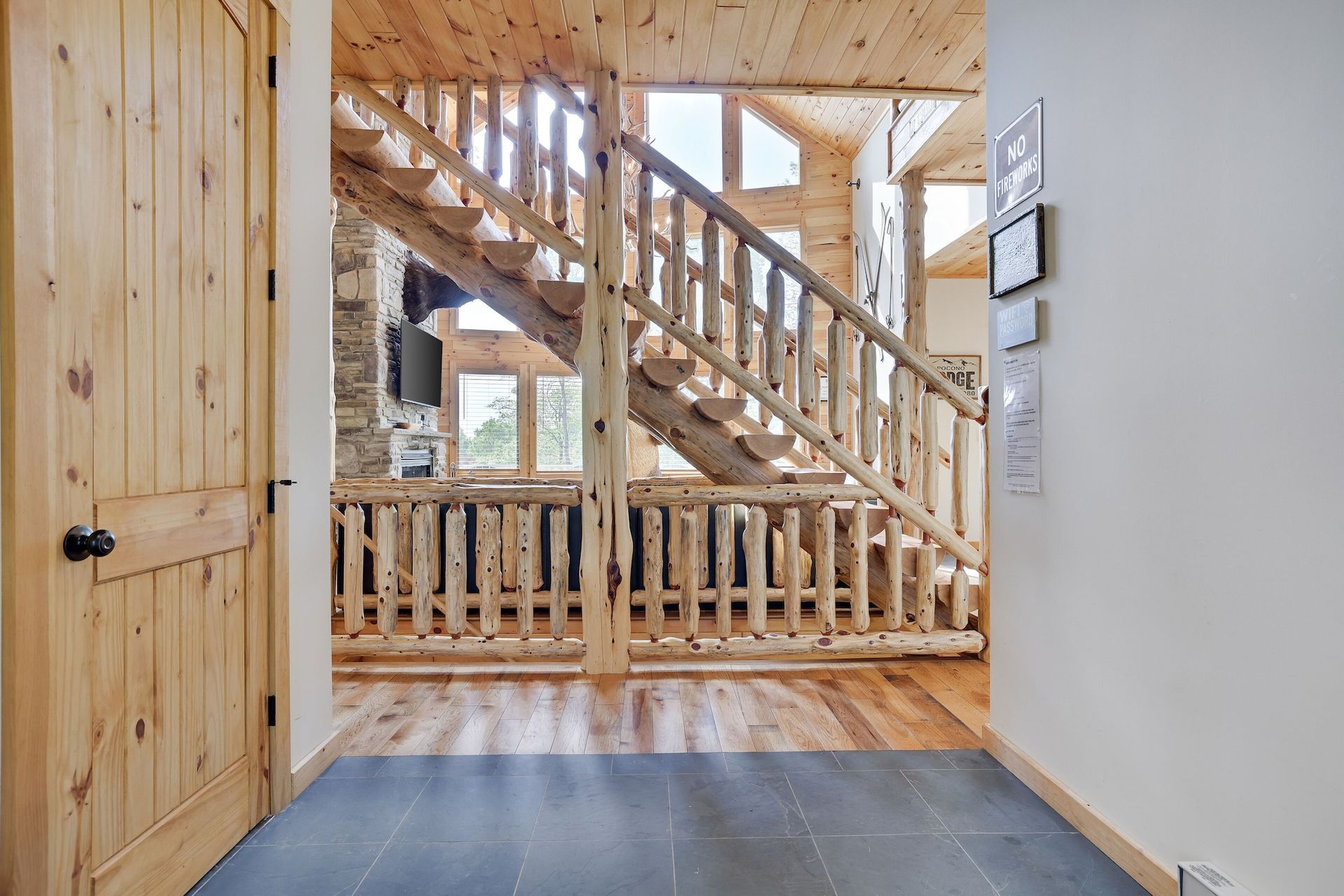 A wooden staircase is leading up to the second floor of a log cabin.