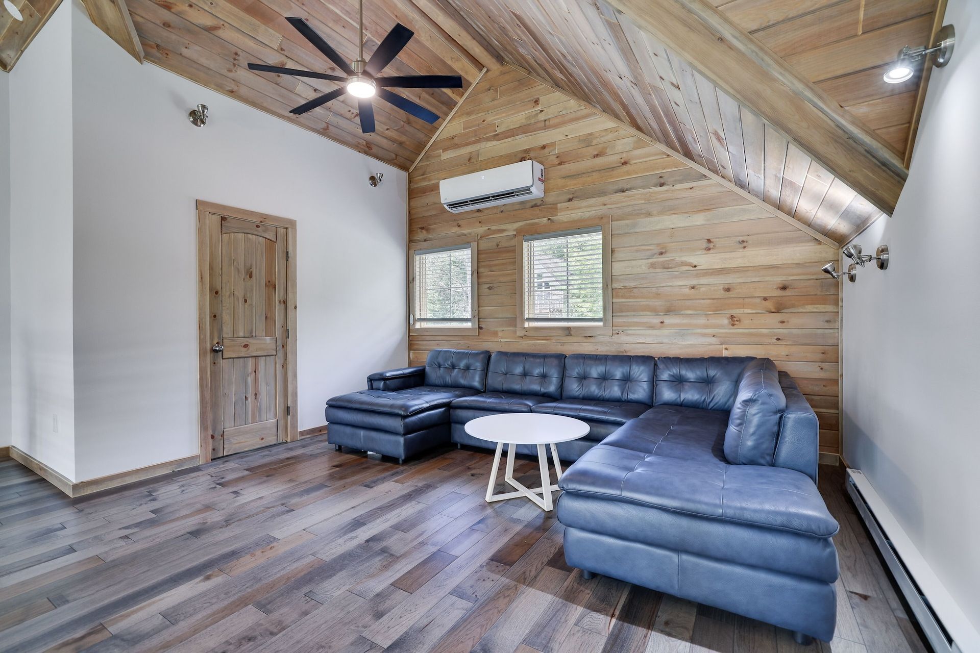 A living room with a couch , table , and ceiling fan.