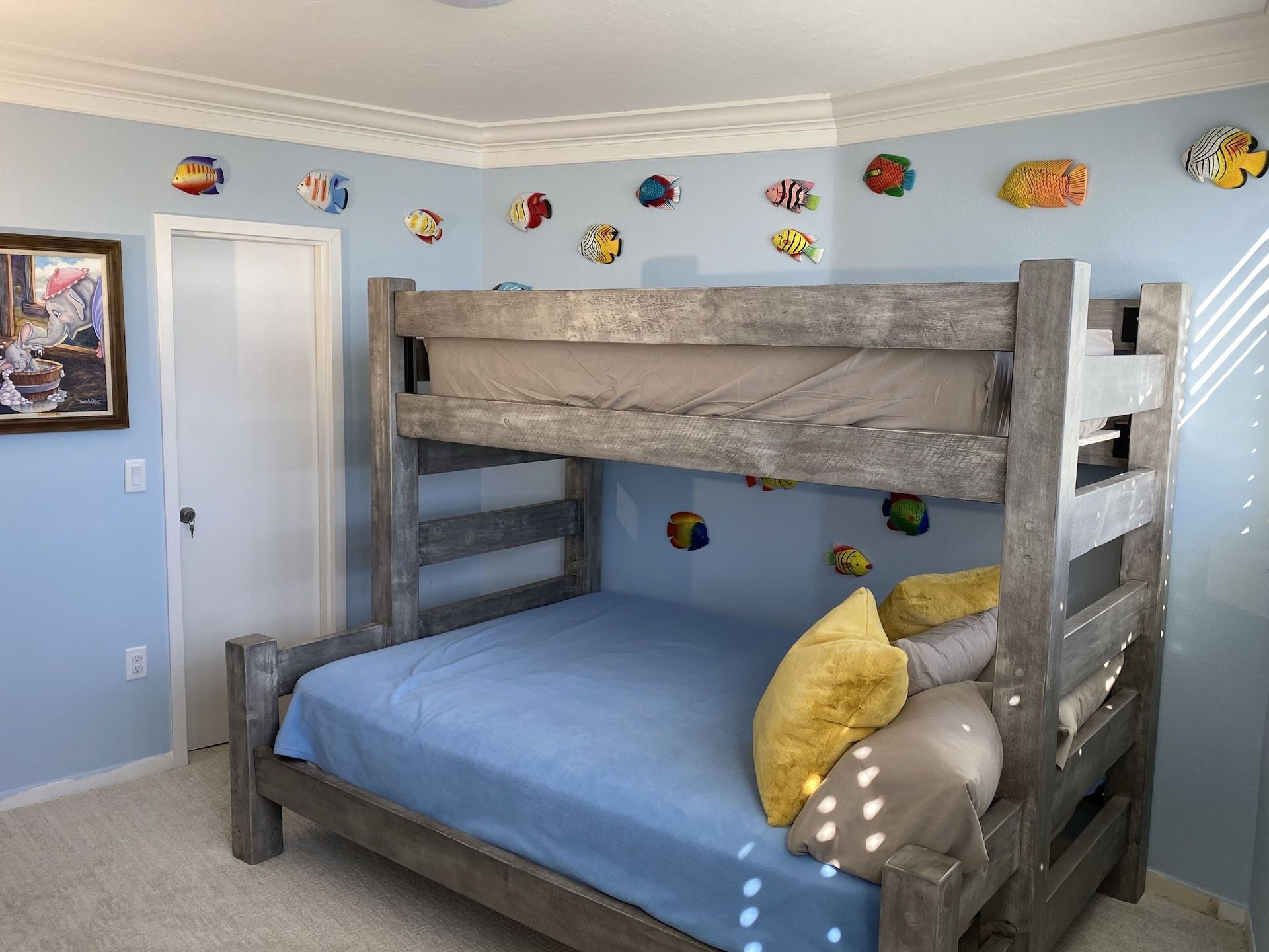A bedroom with a bunk bed and fish on the wall.