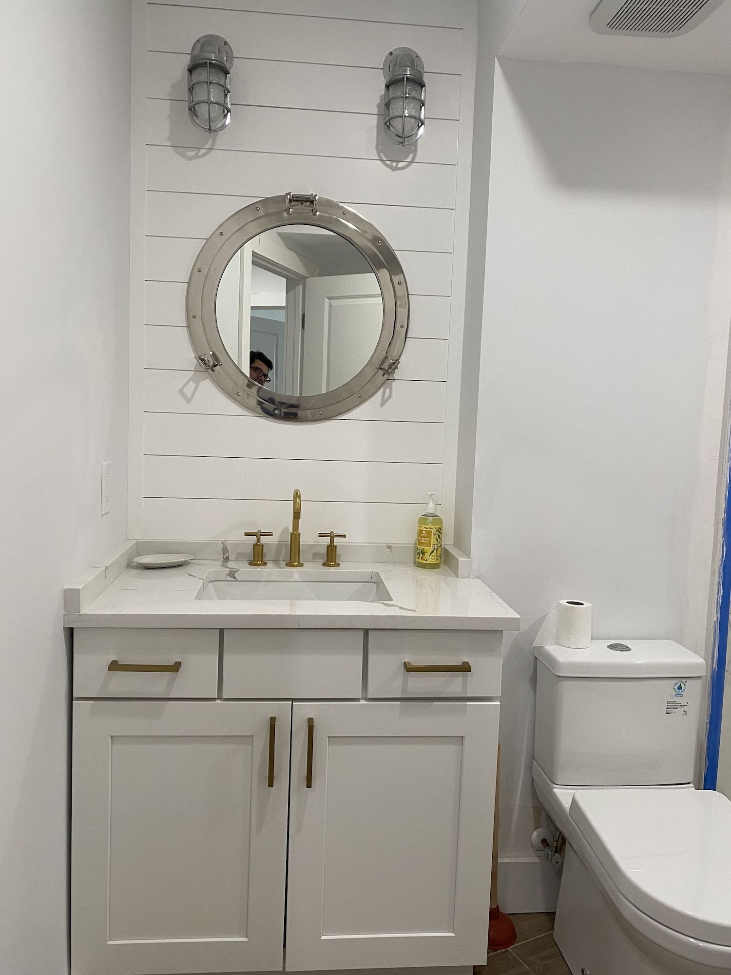 A bathroom with a sink , toilet and mirror.