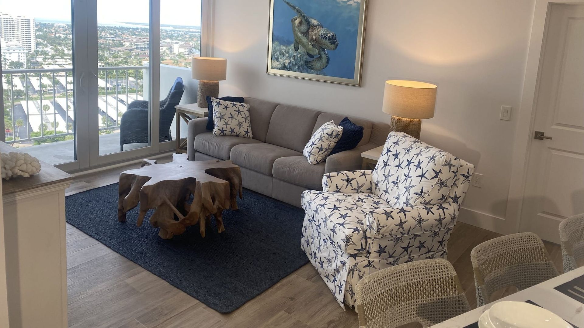 A living room with a couch , chair , table and a painting on the wall.